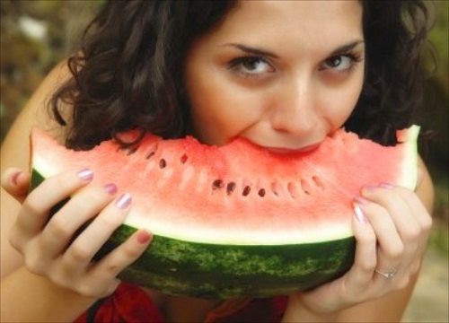 young woman eating a piece of watermelon